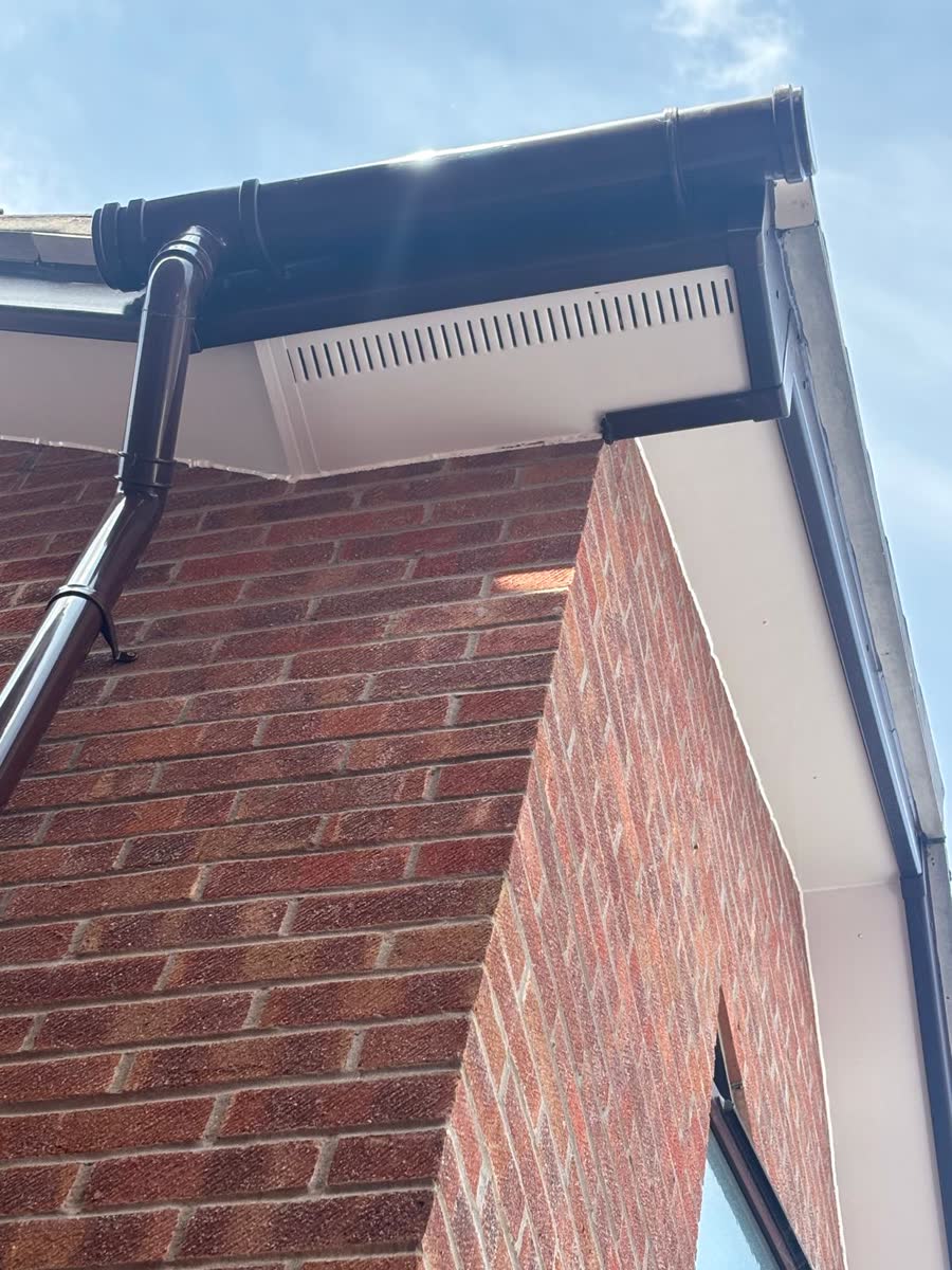 Black guttering and vented soffit on a brick corner in Bristol