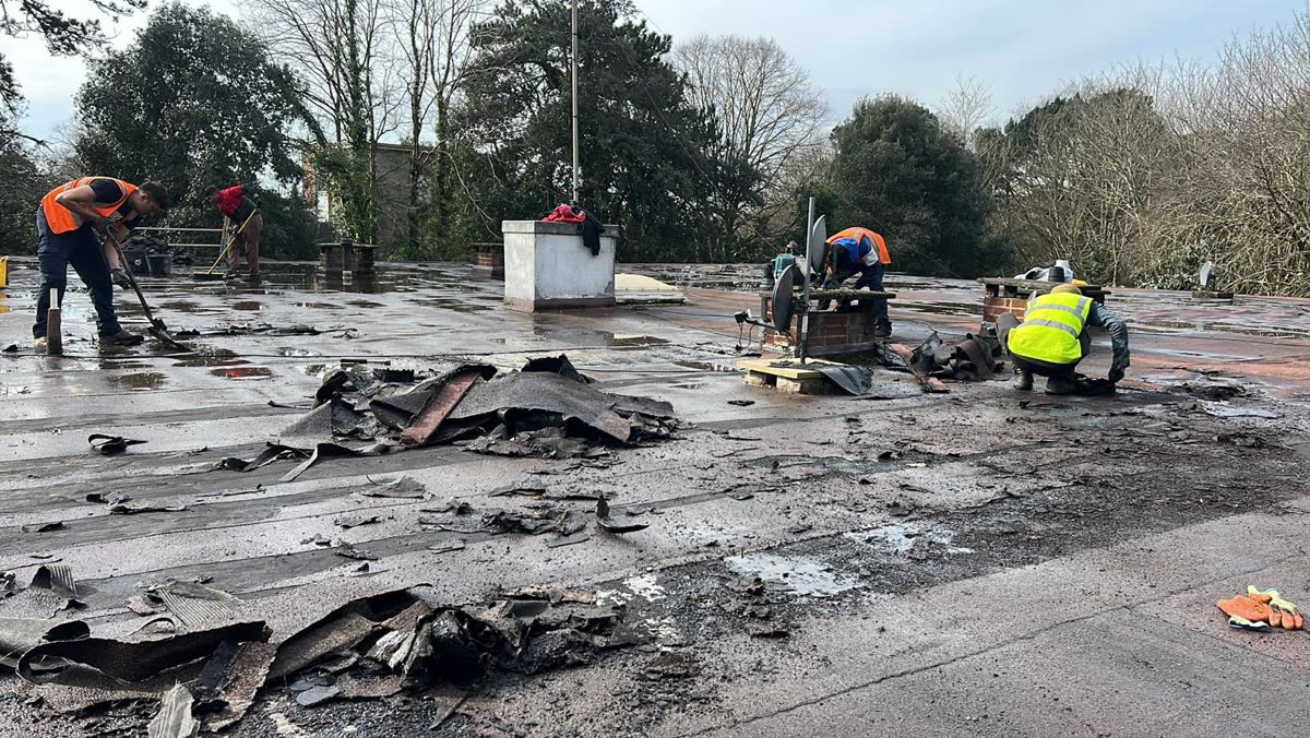 Old felt being stripped from a flat roof in Shirehampton
