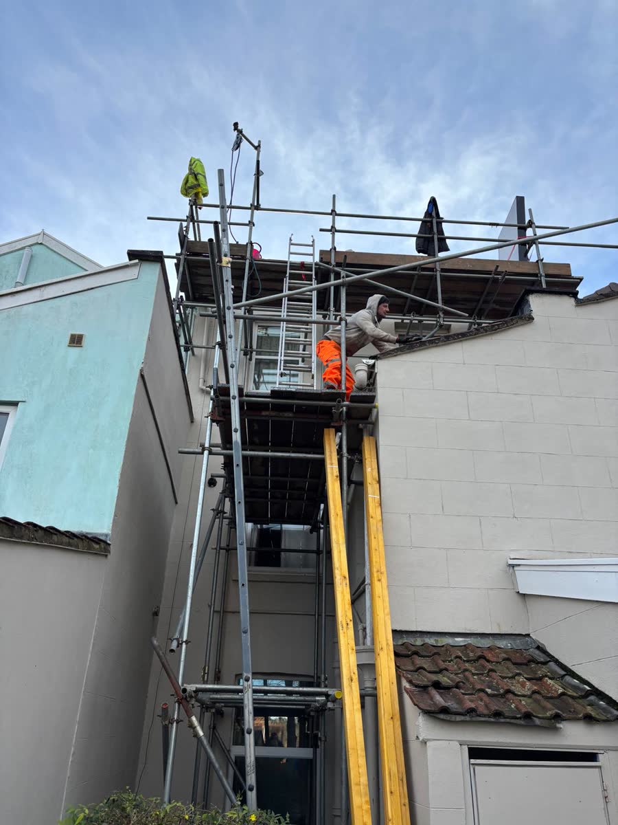 Roofer working from a scaffold tower on a terrace in Bristol