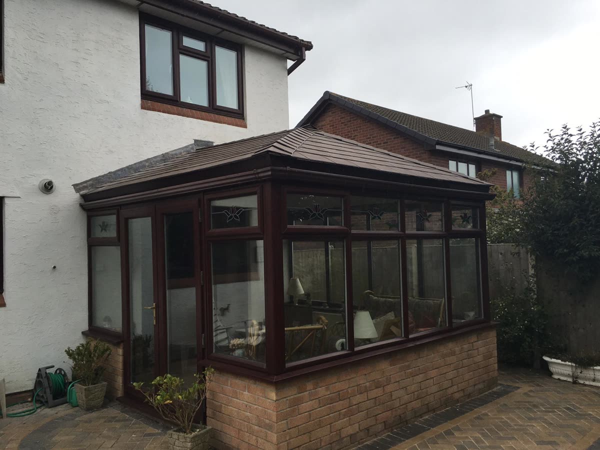 Conservatory finished with a solid brown tiled roof, Henleaze