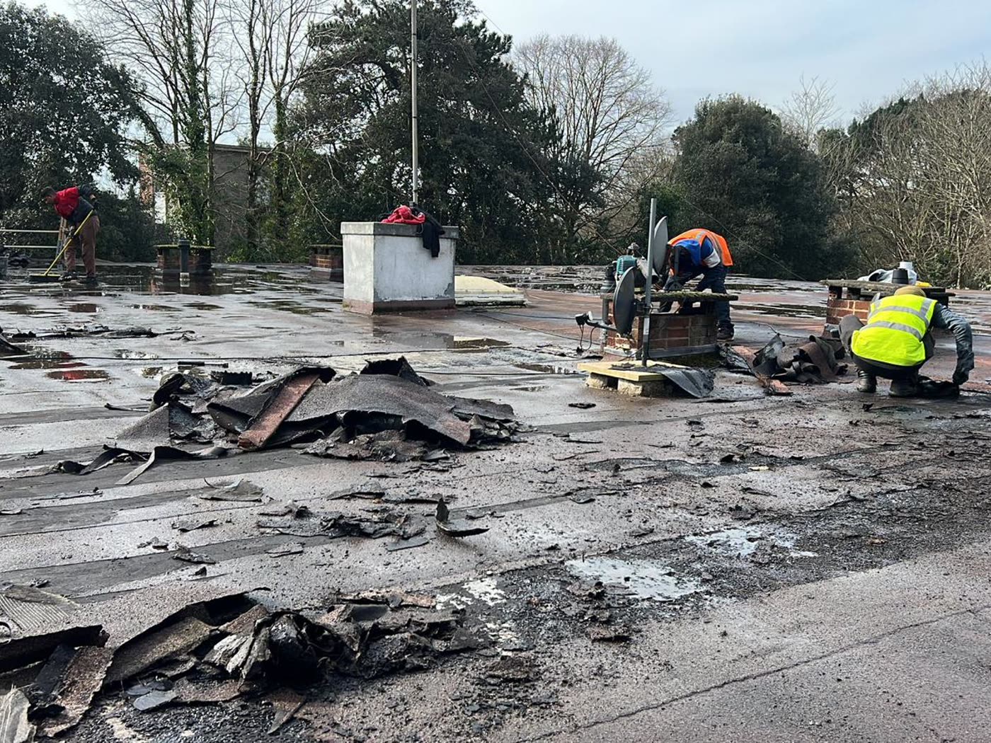 Team stripping the old felt from a large flat roof in Fishponds