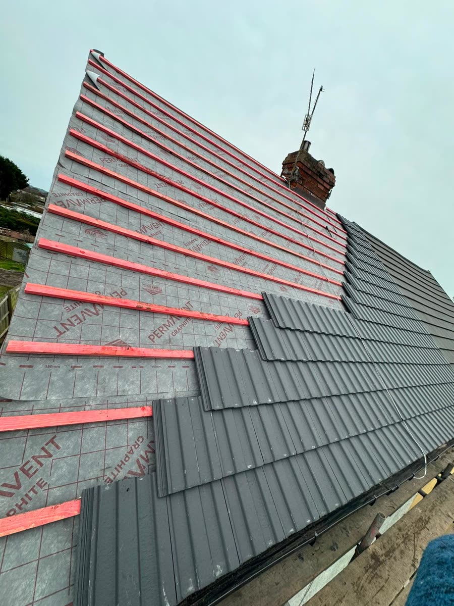 Grey concrete tiles going on over new battens, Nailsea