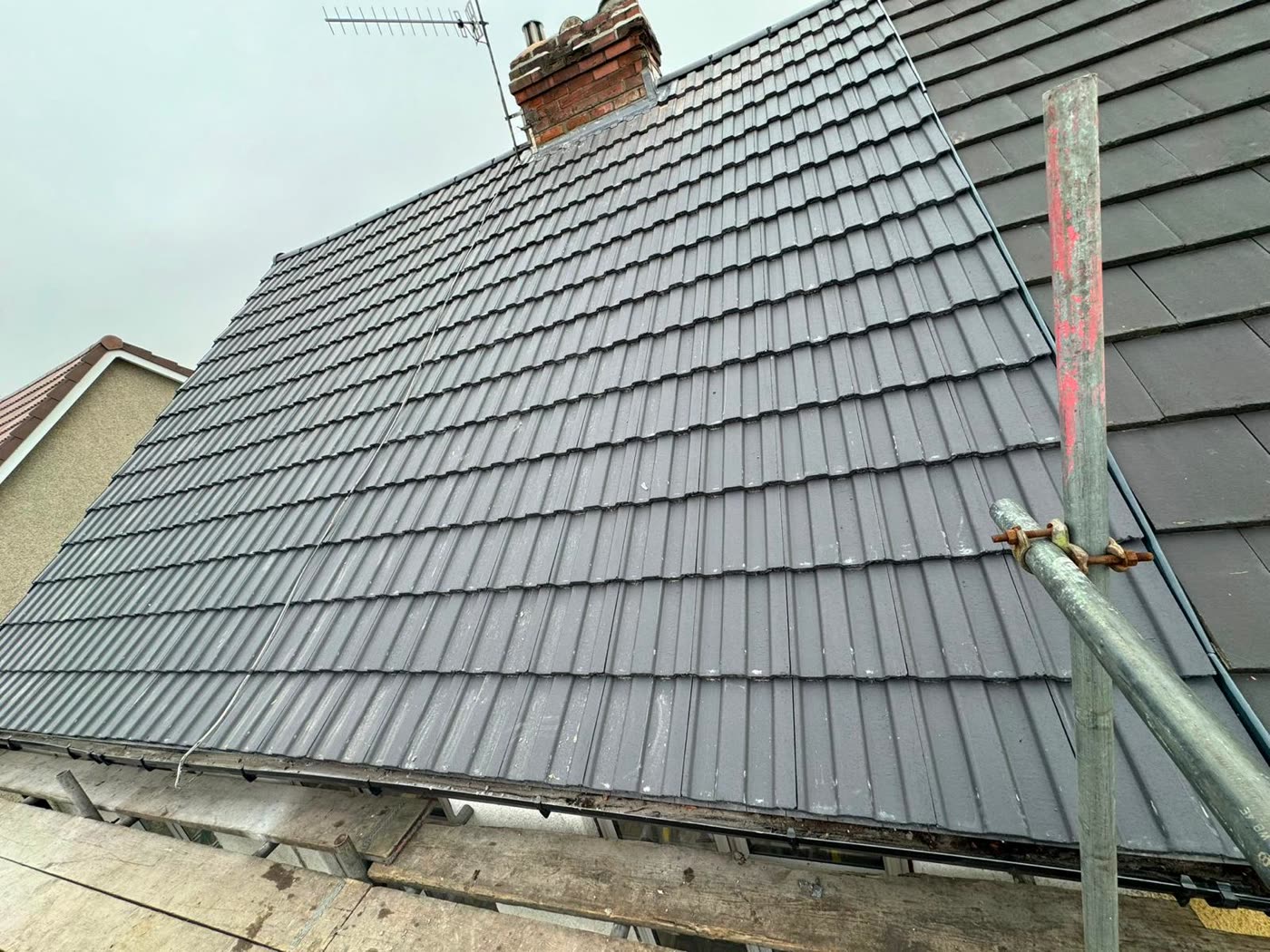 Finished grey tiled roof with the chimney flashed in in Bishopston