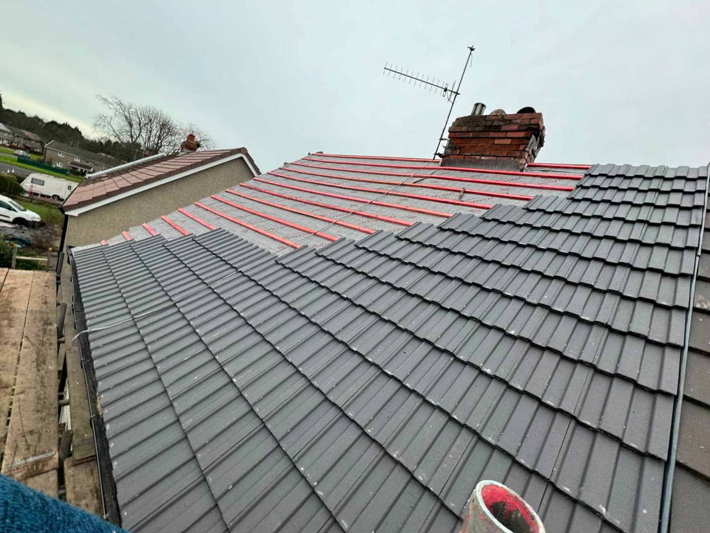 Grey interlocking tiles going on over new membrane and battens in Bishopston